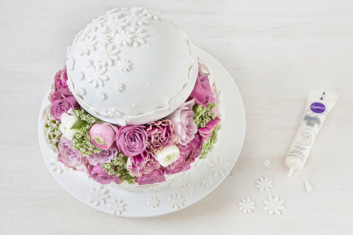Auffällige Hochzeitstorte mit üppiger Blumendeko in Weiß und Pastell