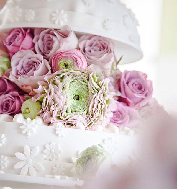 Blumendeko auf Hochzeitstorte in Kuppel-Optik in Weiß