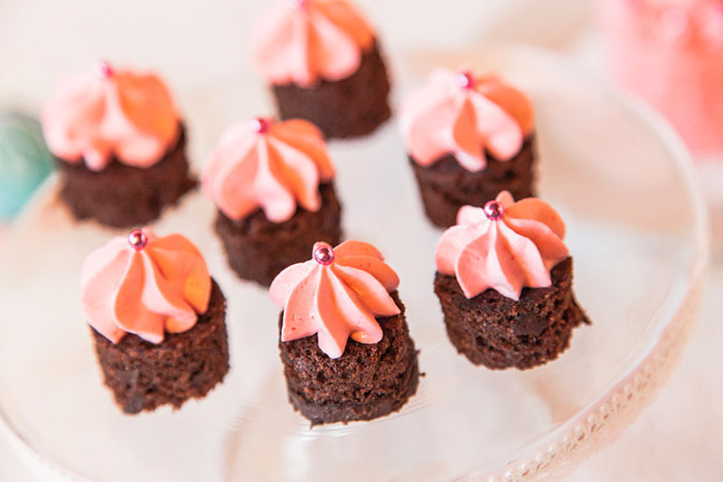 Mini-Kuchen mit rosa Sahnehaube und Deko