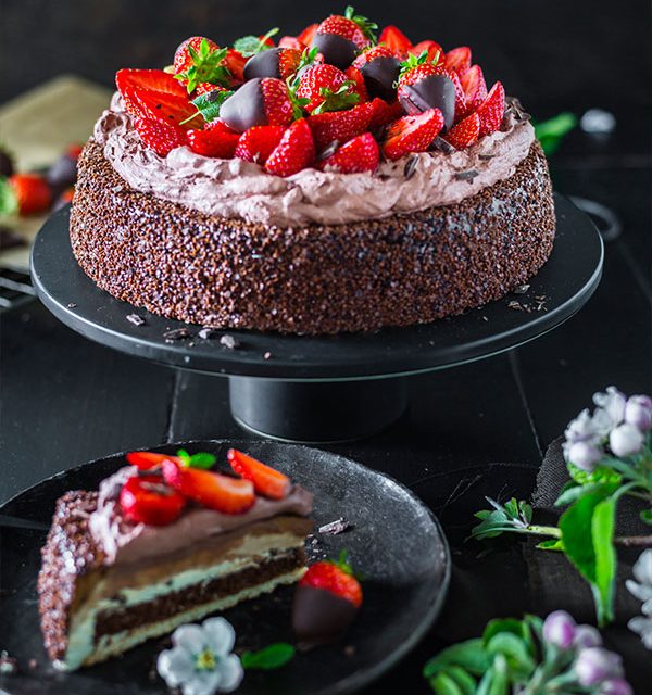 Schokoladen Erdbeertorte und Kuchenstück mit frischen Erdbeeren verziert