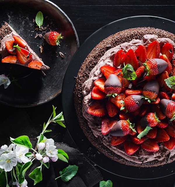 Schokoladentorte und Tortenstück mit frischen Erdbeeren verziert